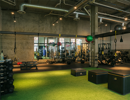 Modern fitness center with workout equipment and turf training area, illustrating health & wellness spaces ideal for turnkey ATM placement services.